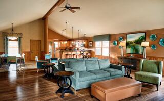 A stylish open-concept living area features a cozy sofa, colorful accents, and warm wood tones, creating a welcoming atmosphere.