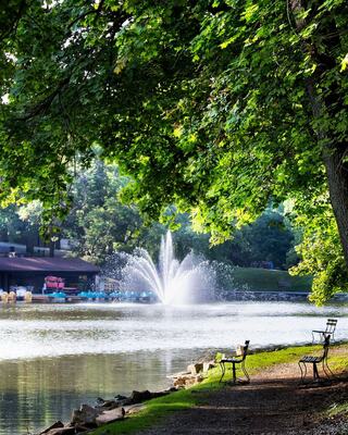 Two children paddle a bright yellow kayak on calm waters, wearing life jackets and enjoying a sunny day outdoors.