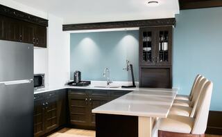 A spacious bathroom features a soaking tub, dual sinks with a granite countertop, modern fixtures, and a glass-enclosed shower.