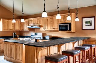 A stylish open-concept living area features a cozy sofa, colorful accents, and warm wood tones, creating a welcoming atmosphere.