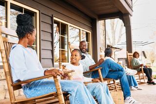 A joyful family plays together in a park filled with autumn leaves, capturing laughter and warmth in a heartwarming moment.