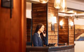 A child in a purple hat beams while gazing out a bus window, surrounded by smiling adults. Joyful atmosphere with festive lights outside.
