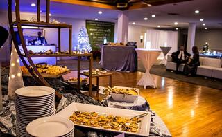 A beautifully set event space with elegant food displays, white tables, and festive decor, creating a celebratory atmosphere.