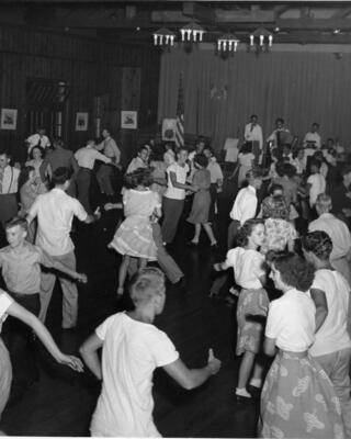 A lively dance scene from the past, featuring couples twirling and enjoying music in a festive hall, capturing joyful moments of celebration.