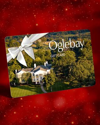 A gift card featuring a scenic view of a grand white mansion, adorned with a large bow, set against a festive red background.
