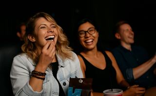 Four friends enjoy a fun outing at the movies, sharing laughter and snacks in a cozy, relaxed atmosphere.