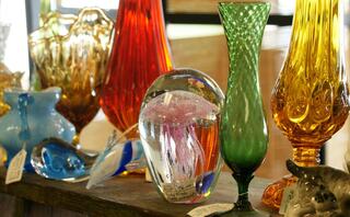 A colorful display of glass vases and decorative pieces in various shapes and sizes, showcasing vibrant hues and intricate designs.