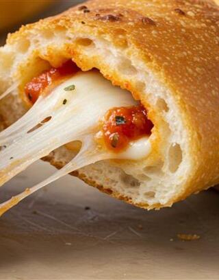 Melted cheese stretches invitingly from a golden, crispy bread, revealing a rich tomato sauce inside. Perfectly appetizing!