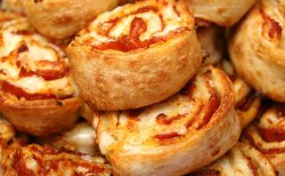 Golden-brown, cheesy rolls with swirls of pepperoni, stacked enticingly in a pile, inviting and ready to be enjoyed.
