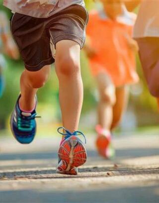 Children run energetically on a sunny path, vibrant sneakers striking the ground, embodying joy and the spirit of play.