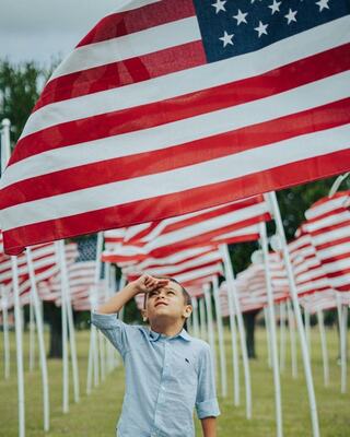 A boy in a festive hat enjoys watermelon with friends, creating a joyful summer scene filled with fun and laughter.