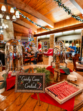 A cozy holiday setting features a festive tree, cheerful decorations, and a table with hot cocoa and treats, inviting warmth and celebration.