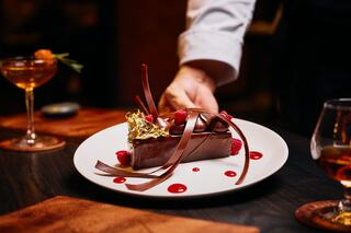 A delicious indulgence featuring layers of chocolate and vanilla ice cream, bananas, cookies, chocolate sauce, and cherries on top.