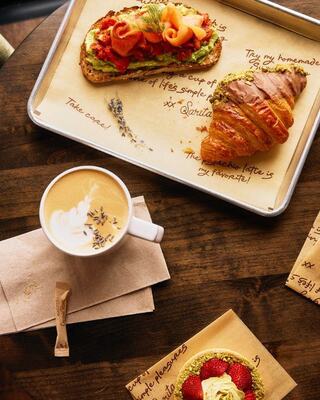 A cozy cup of latte with lavender sprinkles sits beside a flaky croissant, inviting warmth and indulgence.